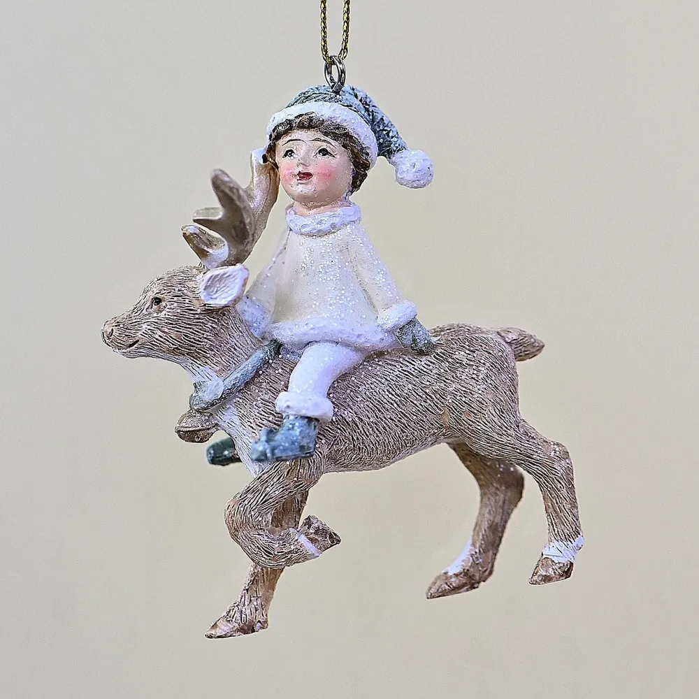 Mädchen auf Rentier hellem Kleidchen